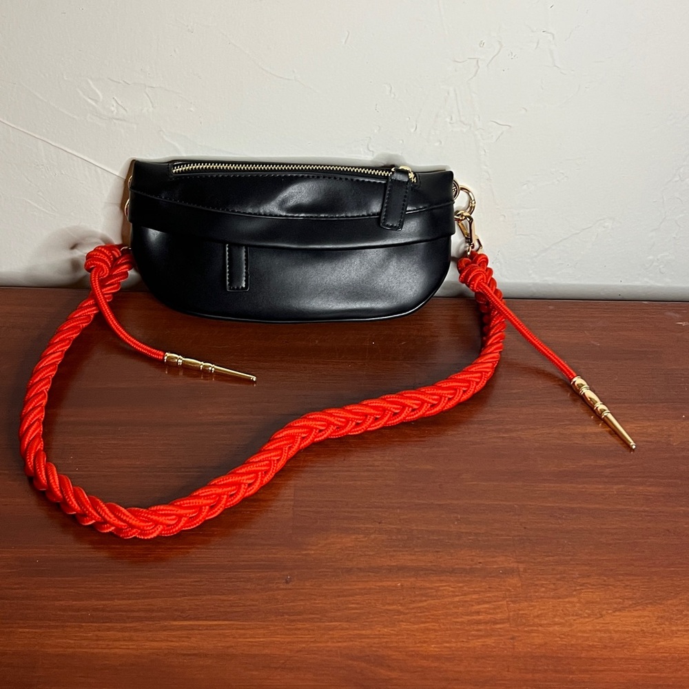 Black Crossbody Bag with Red Strap and Round Shape